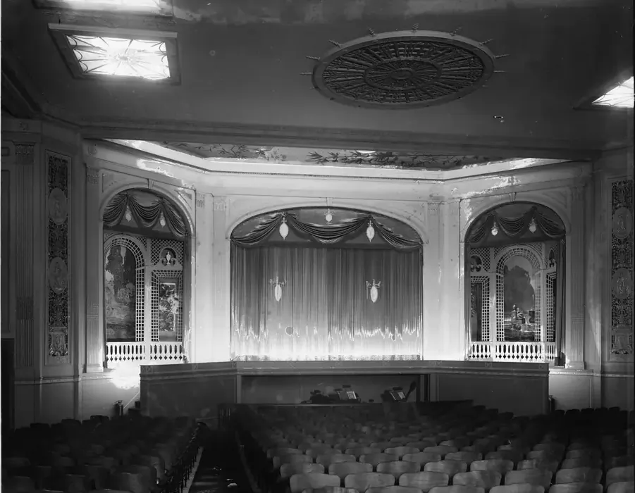A historic theater interior with a proscenium stage